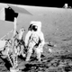 Conrad standing next to Surveyor 3, with the Lunar Module in the background. (NASA)